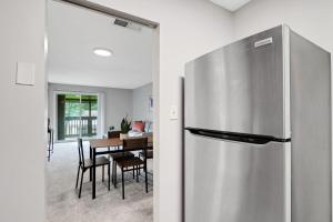 a kitchen with a refrigerator and a table with chairs at Sweetwater 5f I Beautiful 1bd Apt I Free Parking in Gainesville