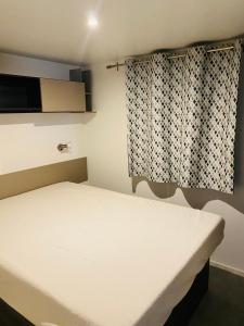 Ένα ή περισσότερα κρεβάτια σε δωμάτιο στο Mobil home de standing à la Porte des Cévennes sur un terrain arboré et ombragé