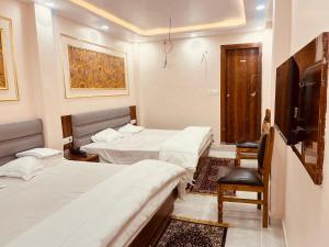 a hotel room with two beds and a television at SHRI ANANDAM Inn in Isauli +19 photos