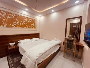 a bedroom with a bed and a painting on the wall at SHRI ANANDAM Inn in Isauli