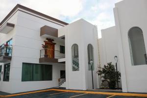 a white building with windows and a parking lot at Belova Luxury Hotel, San Cristobal de las Casas in San Cristóbal de Las Casas