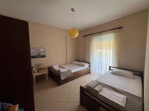 a bedroom with two beds and a window at Sea & Sun Retreat in Nea Vrasna