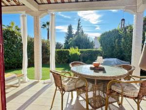patio ze stołem i krzesłami na ganku w obiekcie Holiday Sun Villa w mieście Villeneuve-Loubet