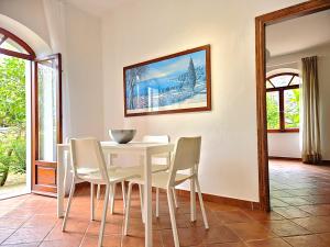 a dining room with a white table and chairs at I Fiori di Salici in Capoliveri