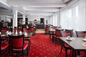 a dining room with tables and red chairs at Best Western Hotel Heide in Oldenburg