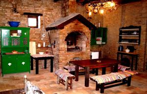 een keuken met een bakstenen oven met een tafel en stoelen bij Guest House Stara Baranja in Kneževi Vinogradi