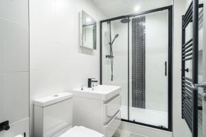 a white bathroom with a toilet and a shower at Convenient 1 Bedroom Apartment in Preston Centre in Preston