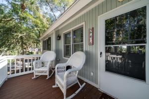 two wicker chairs sitting on the front porch of a house at 546 Tarpon Pond Cottage in Seabrook Island