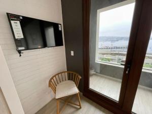 a chair in a room with a large window at HOM I Duplex en Mejor Vista de Valparaiso y Parking in Valparaíso