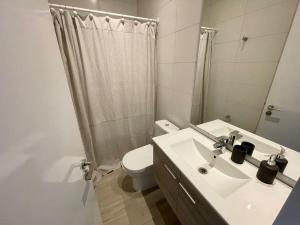 Un baño con lavabo, inodoro y ducha. en HOM I Duplex en Mejor Vista de Valparaiso y Parking, en Valparaíso