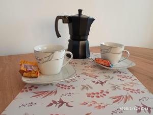 a coffee maker and two cups on a table at Słoneczne Centrum Apartament in Suwałki