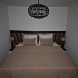 Un dormitorio con una cama y una lámpara de araña. en Het Klokkenest, en Katwijk aan Zee