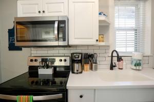 a kitchen with a stove and a microwave at Sojourn at Colley Manor Unit 6 in Norfolk