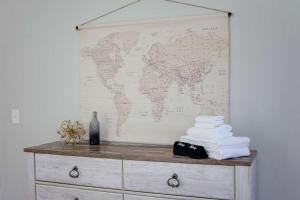 a map of the world on a wall above a dresser at Sojourn at Colley Manor Unit 6 in Norfolk +23 photos