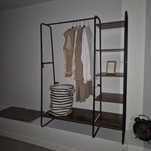 a black rack with clothes and a stack of towels at Het Klokkenest in Katwijk aan Zee