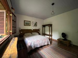 a bedroom with a bed and a mirror in it at Chácara portal do dragão casa completa para 6 pax in Paraty