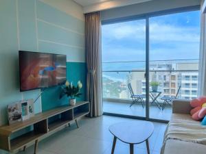 a living room with a couch and a large window at The Sóng Vũng tàu -Thuỷ còi in Vung Tau