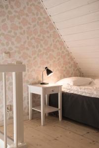 a bedroom with a bed and a desk with a lamp at Munkamöllan Logi Skåne Tranås in Skåne-Tranås