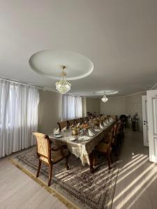 una lunga sala da pranzo con un lungo tavolo e sedie di Ak Orgo House a Karakol