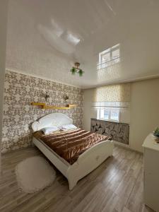 una camera da letto con un letto grande in una stanza di Ak Orgo House a Karakol