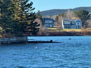 two houses on the shore of a body of water at Acadia Horizon Cottage in Southwest Harbor