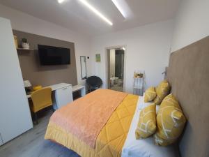 a bedroom with a yellow bed and a desk at La Cartolina del Sannio in Campolattaro