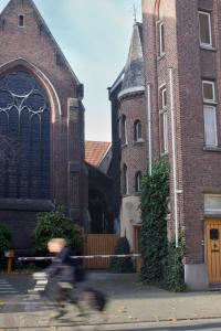 a person riding a bike in front of a building at Guesthouse PoortAckere Ghent in Ghent