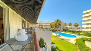 a table on a balcony with a view of a pool at YES! Incrível Vista Piscina T2 HsR Vilamarina in Vilamoura