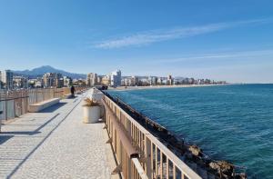 a walkway next to the ocean with a city at Gandia Grau 5 in Gandía