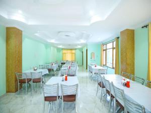 SarāhanHotel Alpine View的摆放着白色桌椅的餐厅