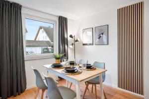 a dining room with a table and chairs and a window at LudwigsCozyEscape - Ruhiges Design-Apartment mit Balkon & Parkplatz, 4 Gäste, SmartTV in jedem Zimmer, Highspeed WLAN, Workspace, 24h Self Check-in in Ludwigsburg