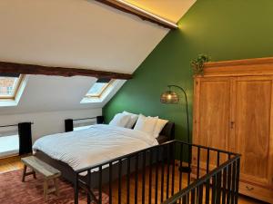 a bedroom with a bed with a green wall at Vakantiewoning Huis 14 in Mechelen