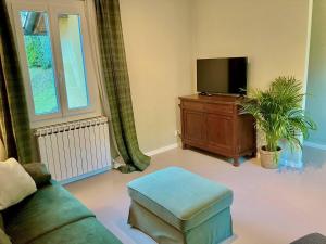 un salon avec un canapé et une télévision dans l'établissement Villa Peroni Honeymoon cottage - with swimming pool, à Argegno