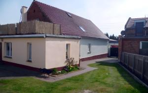 a house with a chicken standing in the yard at Auszeit Landleben in Sallgast