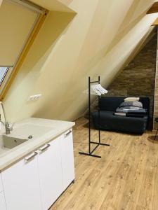 un bagno con divano nero in mansarda di Klebi’s Apartmanház 20 a Balatonföldvár
