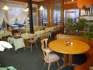 ein Restaurant mit Tischen und Stühlen in einem Zimmer in der Unterkunft Hotel Panorama Windegg in Langnau am Albis