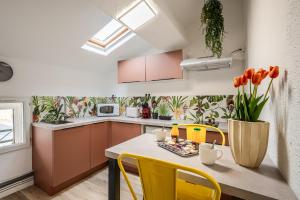 een keuken met een tafel en gele stoelen bij Casa Amor Balnéo Sauna in Lézignan-Corbières