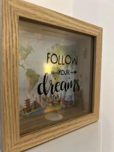 a picture with the words follow your dreams on a window at Serelor Cozy Flat in Dumbrăviţa +9 photos