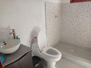 ein Badezimmer mit einer weißen Toilette und einem Waschbecken in der Unterkunft Casa Linda in Villa de Leyva