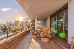 ein Balkon mit Stühlen und einem Tisch auf einem Gebäude in der Unterkunft The Luxury Village by Domidai in Santa Pola