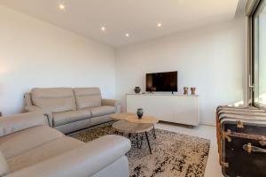 ein Wohnzimmer mit Sofa und Tisch in der Unterkunft The Luxury Village by Domidai in Santa Pola