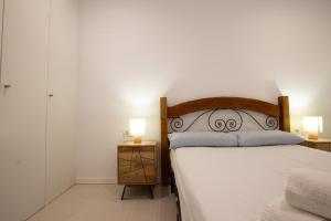 ein Schlafzimmer mit einem Bett und zwei Lampen an Tischen in der Unterkunft The Luxury Village by Domidai in Santa Pola + 23 Fotos