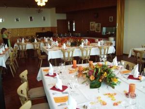 a banquet hall with white tables and chairs with flowers at Hotel Panorama Windegg in Langnau am Albis