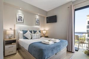 a bedroom with a bed with blue sheets and a window at Forum Ocean View 5B by Homie in Ilhéu do Gorgulho