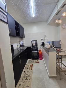 a kitchen with black cabinets and a counter top at Silvia Homes Nanyuki in Nanyuki