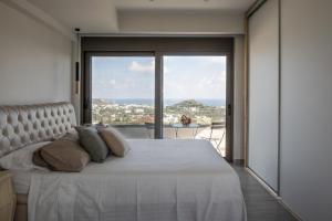 a bedroom with a white bed with a large window at Aetheria Luxury Villa in Kalithies +32 photos