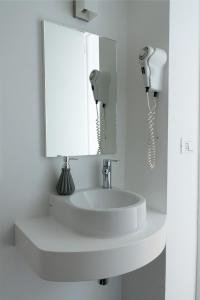 lavabo con espejo y secador de pelo en Graffiti Living Niglio, en Corato
