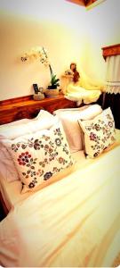 a bedroom with a bed with white sheets and pillows at Ela's Chalet in Old Bazaar Gjirokaster in Gjirokastër