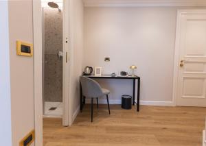a desk in the corner of a room with a chair at Tiburtina 86 Luxury Suites in Rome
