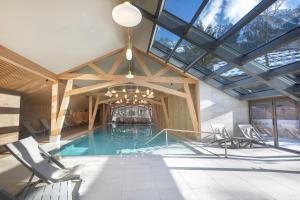 an indoor pool with chairs and a ceiling with windows at Lykke Hôtel & Spa Chamonix - ex Mercure in Chamonix-Mont-Blanc
